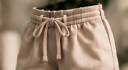 Detalle de unos pantalones cortos beige con cordón